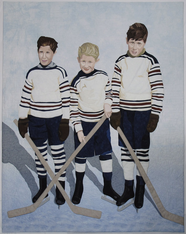 Three boys in vintage hockey uniforms with their skates and hockey sticks.
